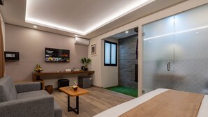 A modern hotel room with a bed, a desk, a sofa, and a TV. - Everyday Hotel Kuta Central (Kuta)
