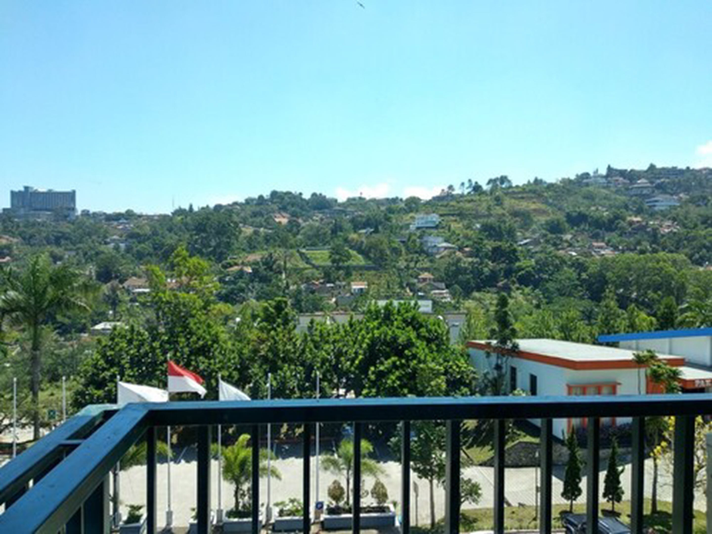 A residential area with a view of a hill with houses and greenery.