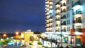A multi-story hotel with balconies, a pool area, and outdoor lighting. - Marbella Suites Bandung (Bandung)