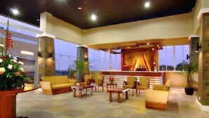 An indoor lounge area with seating arrangements and a bar. - Marbella Suites Bandung (Bandung)
