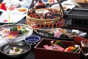 A variety of dishes and a grill, suggesting a dining setup. - Hidatei Hanaougi (Takayama)