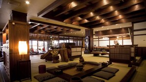 Una habitación tradicional japonesa con suelo de tatami, una mesa baja con cojines y un juego de té.