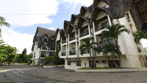 A multi-story hotel with a unique architectural design featuring curved balconies and a central courtyard.