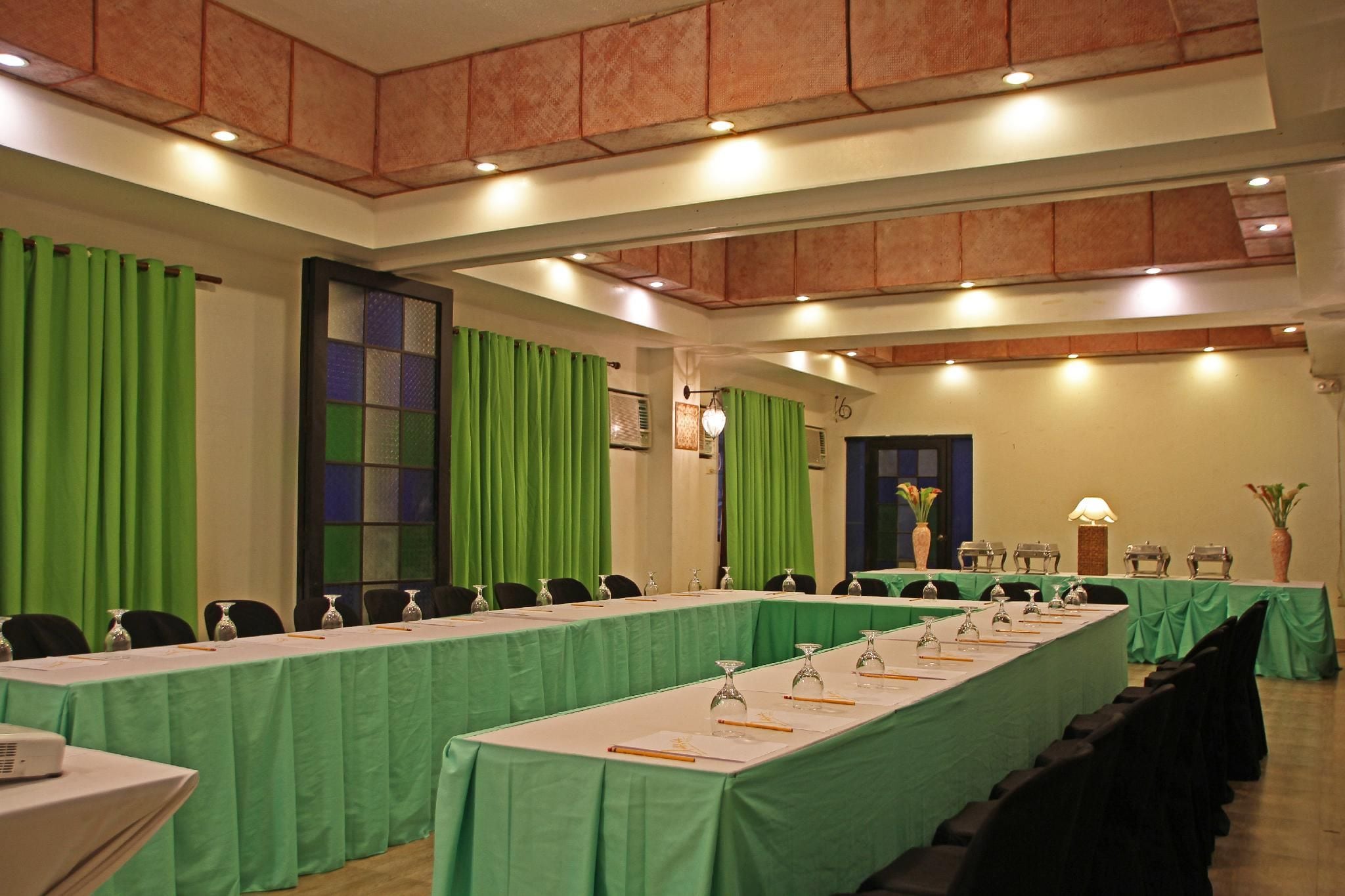 A conference room with long tables, chairs, and a projector.
