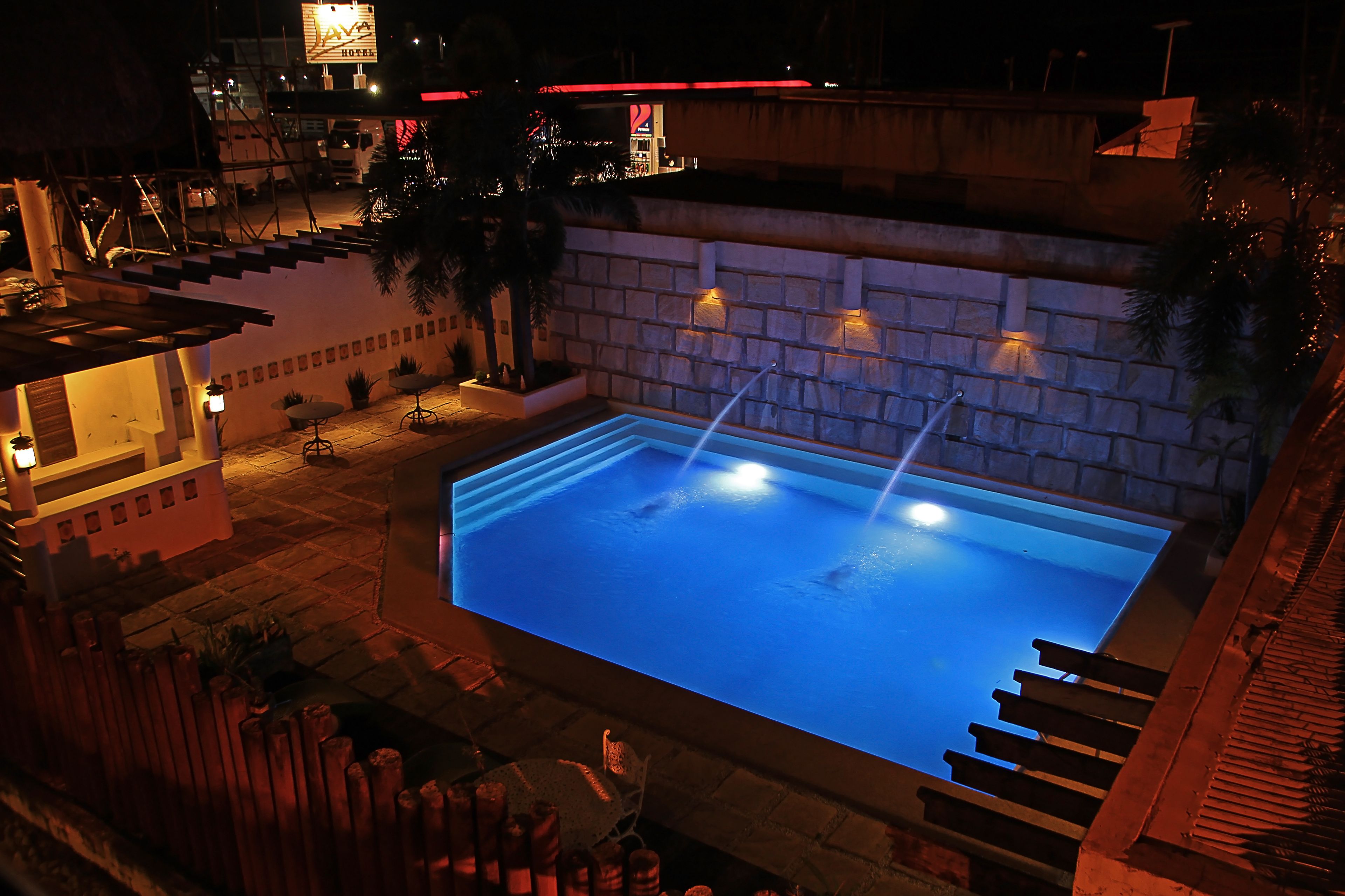 Una piscina al aire libre con un muro de piedra y escalones que la conducen.