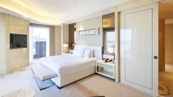 A modern hotel room with a large bed, bedside tables, a TV, and a city view.