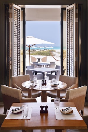 A dining table with chairs, a glass, and a salt shaker. - Park Hyatt Abu Dhabi Hotel & Villas (Abu Dhabi)