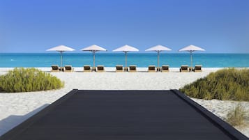 On the beach, white sand, sun-loungers, beach umbrellas