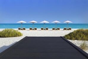 On the beach, white sand, sun-loungers, beach umbrellas