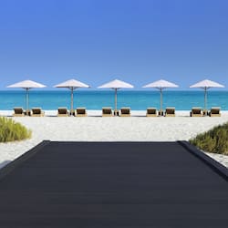 On the beach, white sand, sun loungers, beach umbrellas