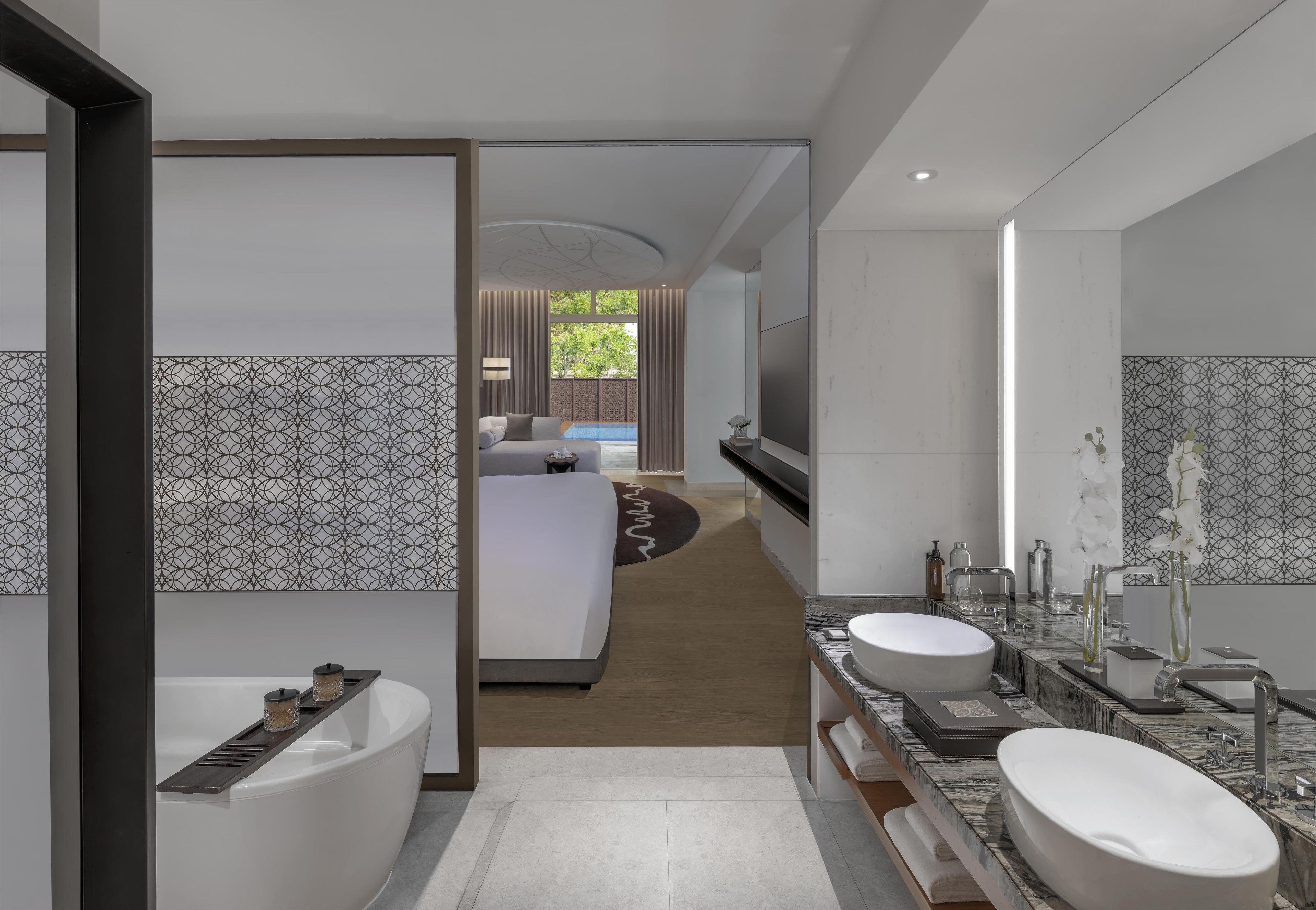 Une salle de bain moderne avec une baignoire, deux lavabos et un grand miroir.
