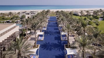Ein Resort mit Pool, Palmen und Blick auf den Strand.