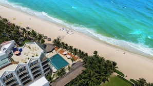 Een resort met zwembad, strand en uitzicht op de oceaan.