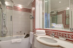 Un bagno con vasca, lavandino e doccia.