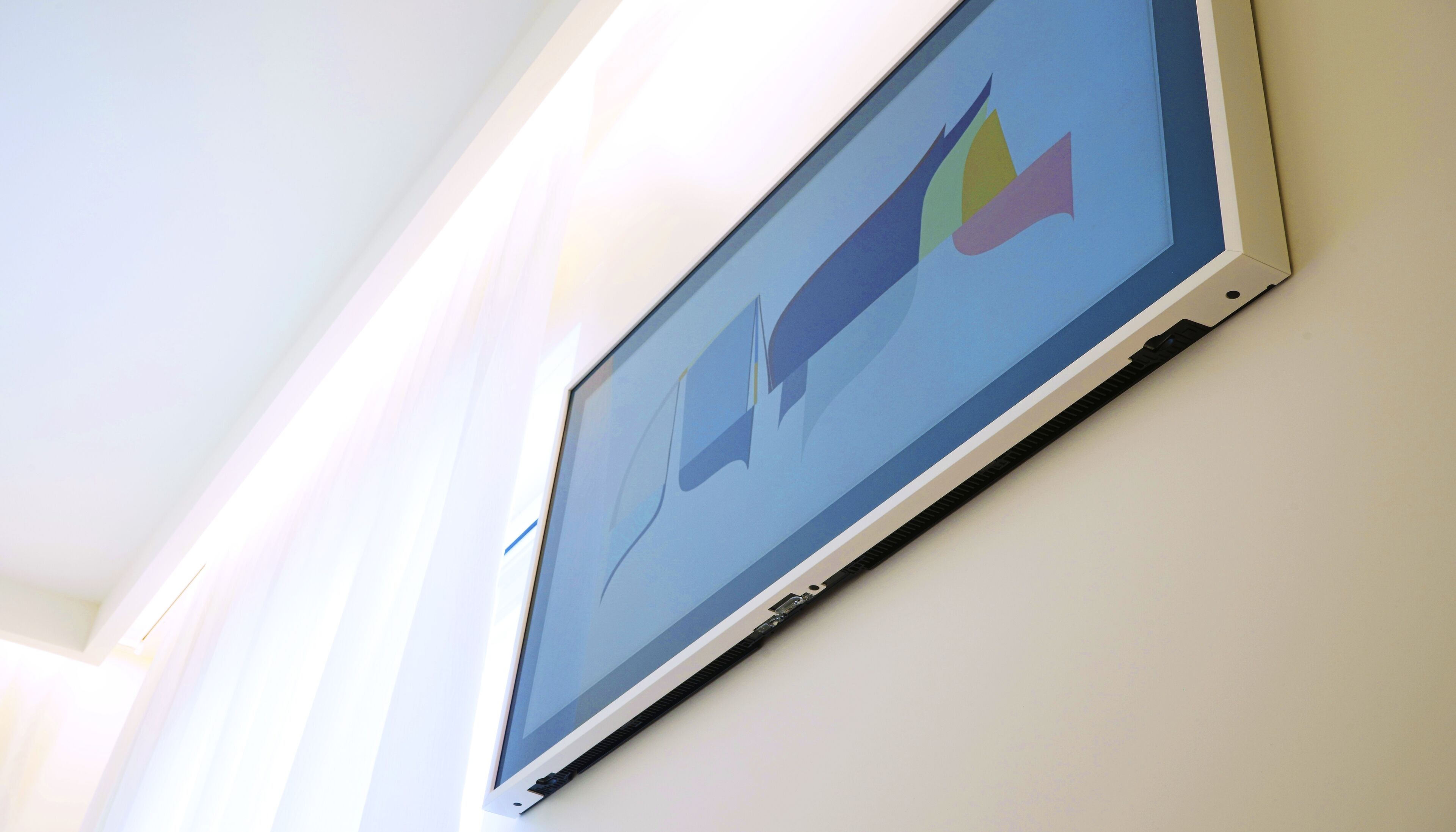 A wall-mounted screen displaying a colorful abstract design.