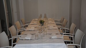 Un salón de conferencias con una larga mesa dispuesta para una reunión.