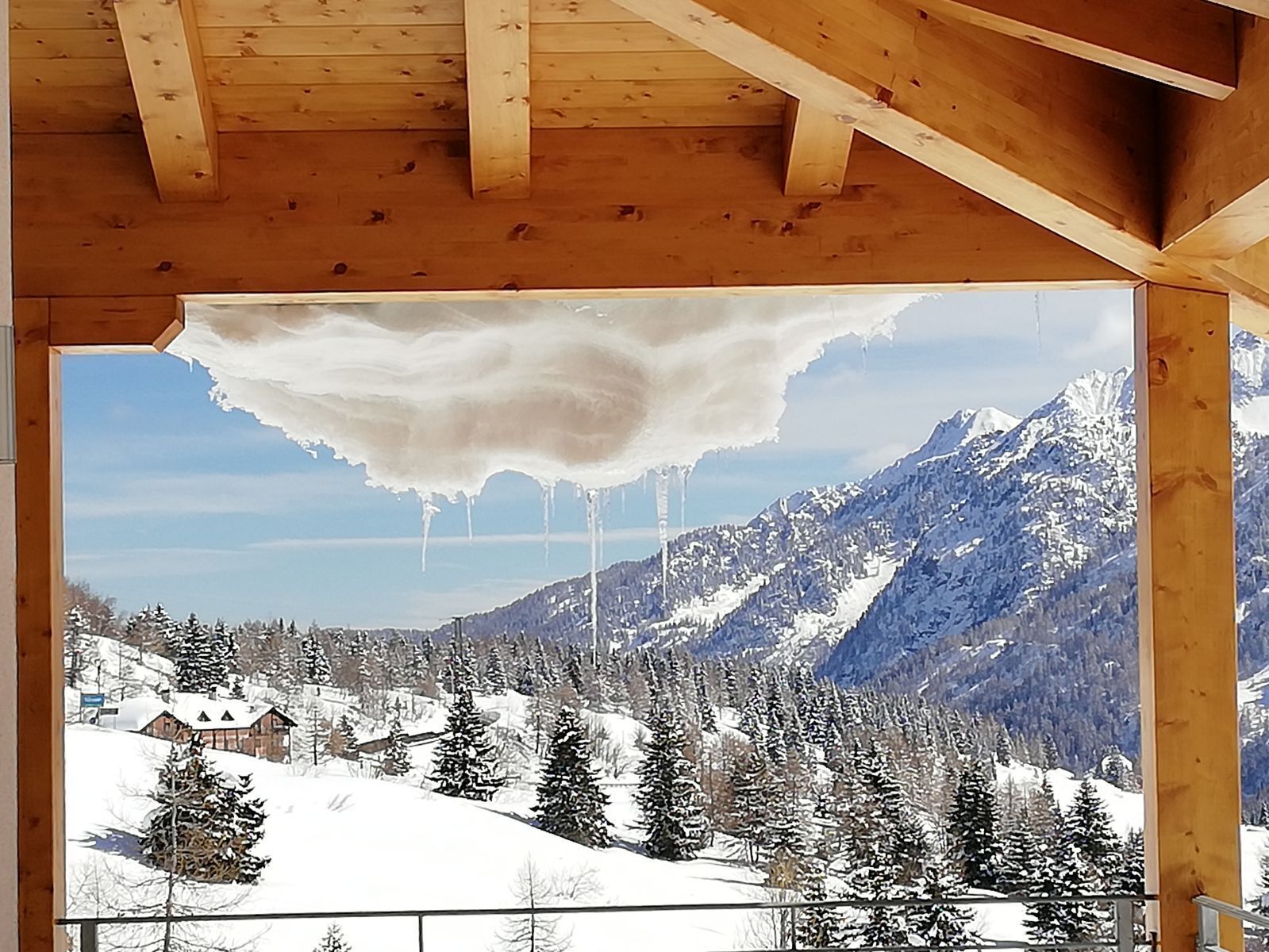 A wooden cabin with a snow-covered mountain view.