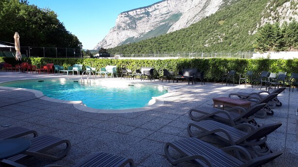 Una piscina al aire libre de temporada, sombrillas