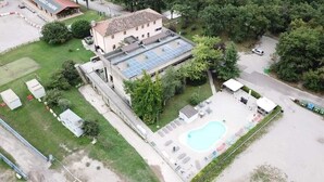 Edificio con piscina, paneles solares y zona de estacionamiento.