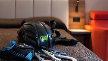 A bed with a patterned bedspread, a black backpack, and a pair of scissors on it.