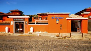 A building with the sign 'POUSADA EL Parador' and 'EL Parador' on the entrance. - Pousada El Parador (Búzios)