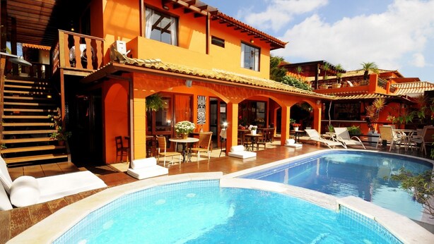 A large house with a swimming pool, outdoor seating, and a covered patio area. - Pousada El Parador (Búzios)