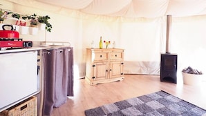 A cozy room with a kitchenette, a wooden cabinet, a stove, and a tented ceiling. - The Old Dairy Farm (Emsworth)