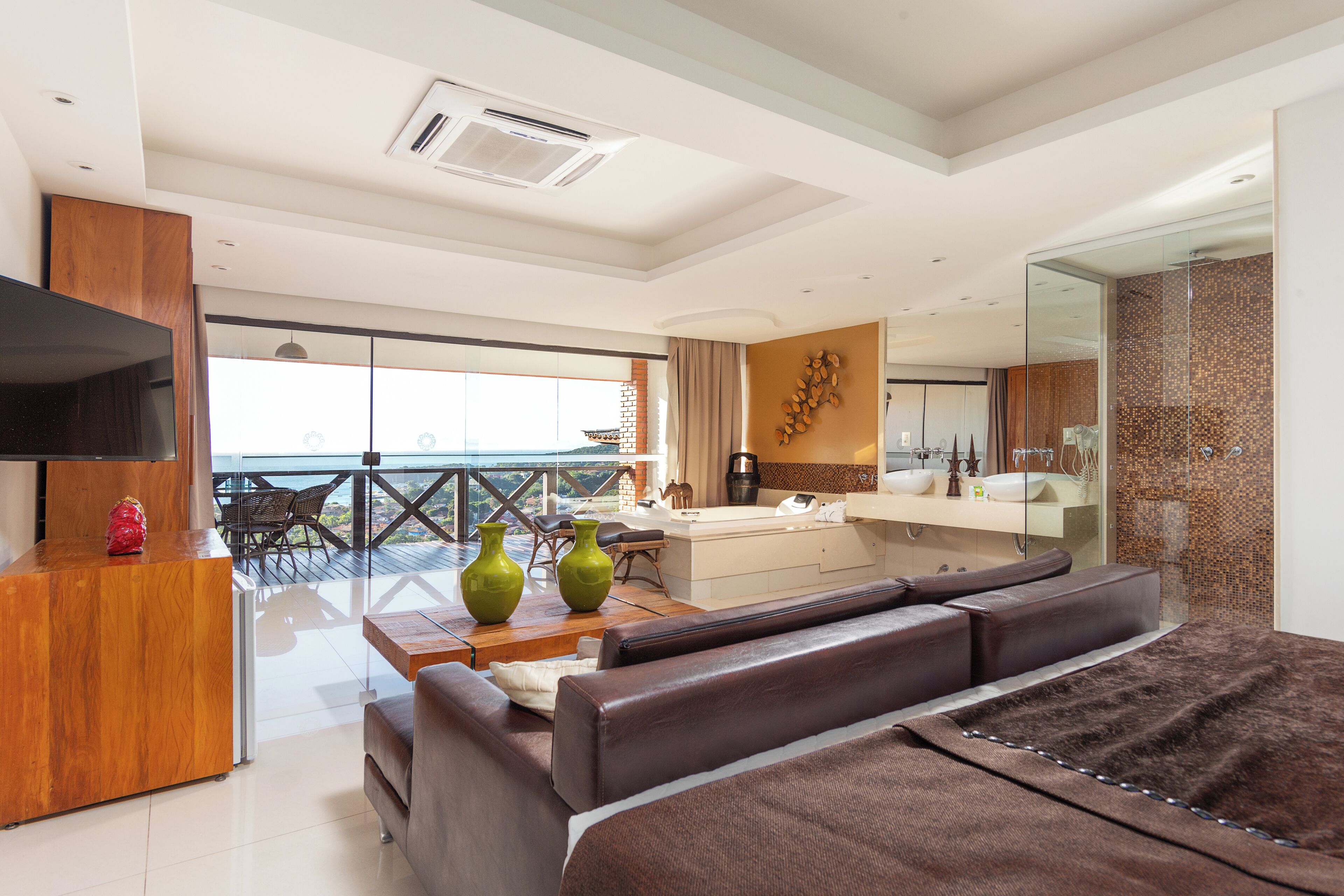 Une chambre d’hôtel moderne dotée d’un balcon, d’un canapé, d’un bureau et d’un grand lit.