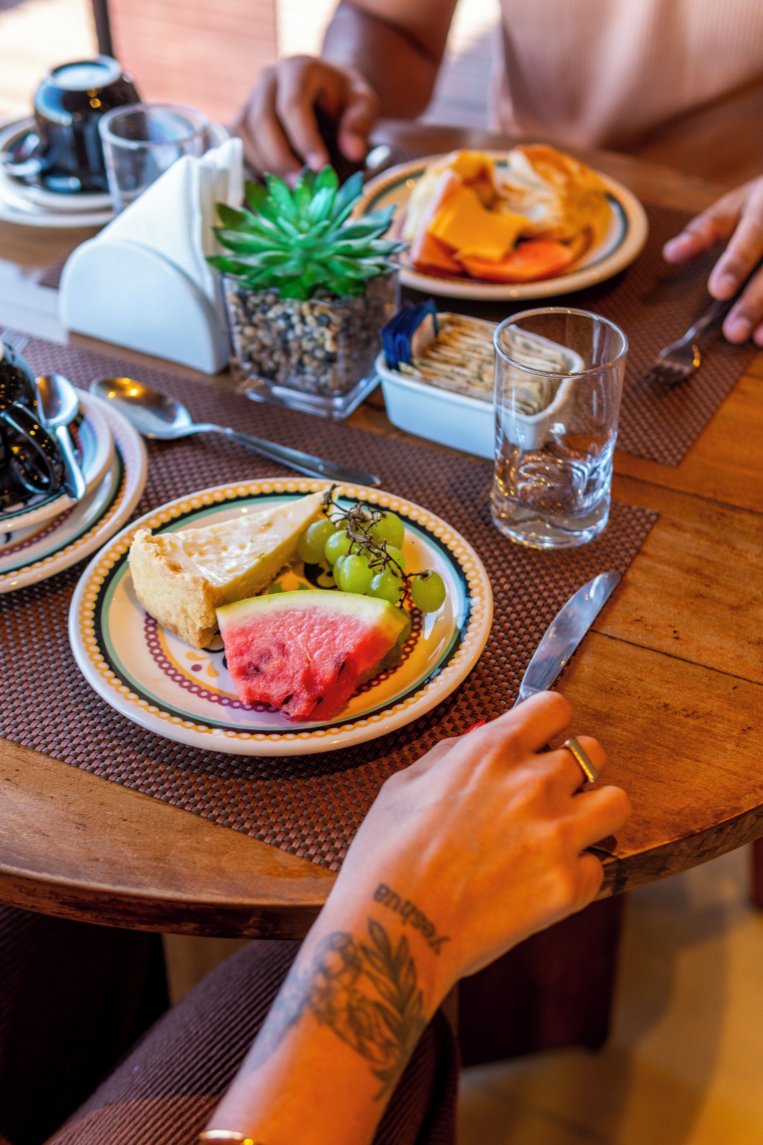 Una mesa de comedor con platos de comida, un vaso de agua y un cuchillo.