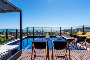 A rooftop infinity pool with lounge chairs and a view of the city. - Costa do Sol Boutique Hotel (Búzios)