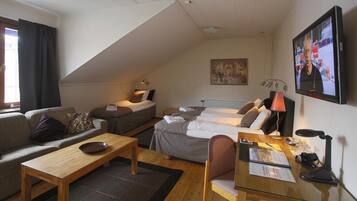 A cozy room with a sofa, a bed, a desk, and a TV.