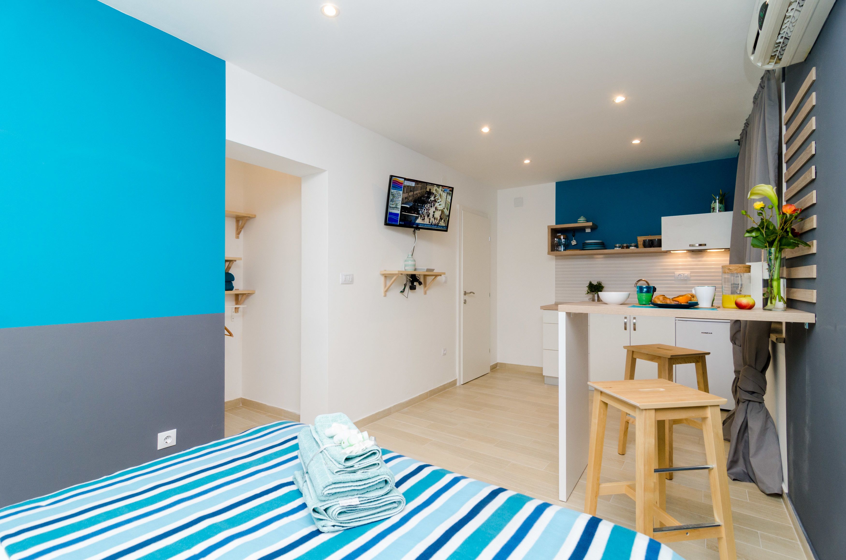 A modern, compact apartment with a kitchen, a dining area, and a bedroom.