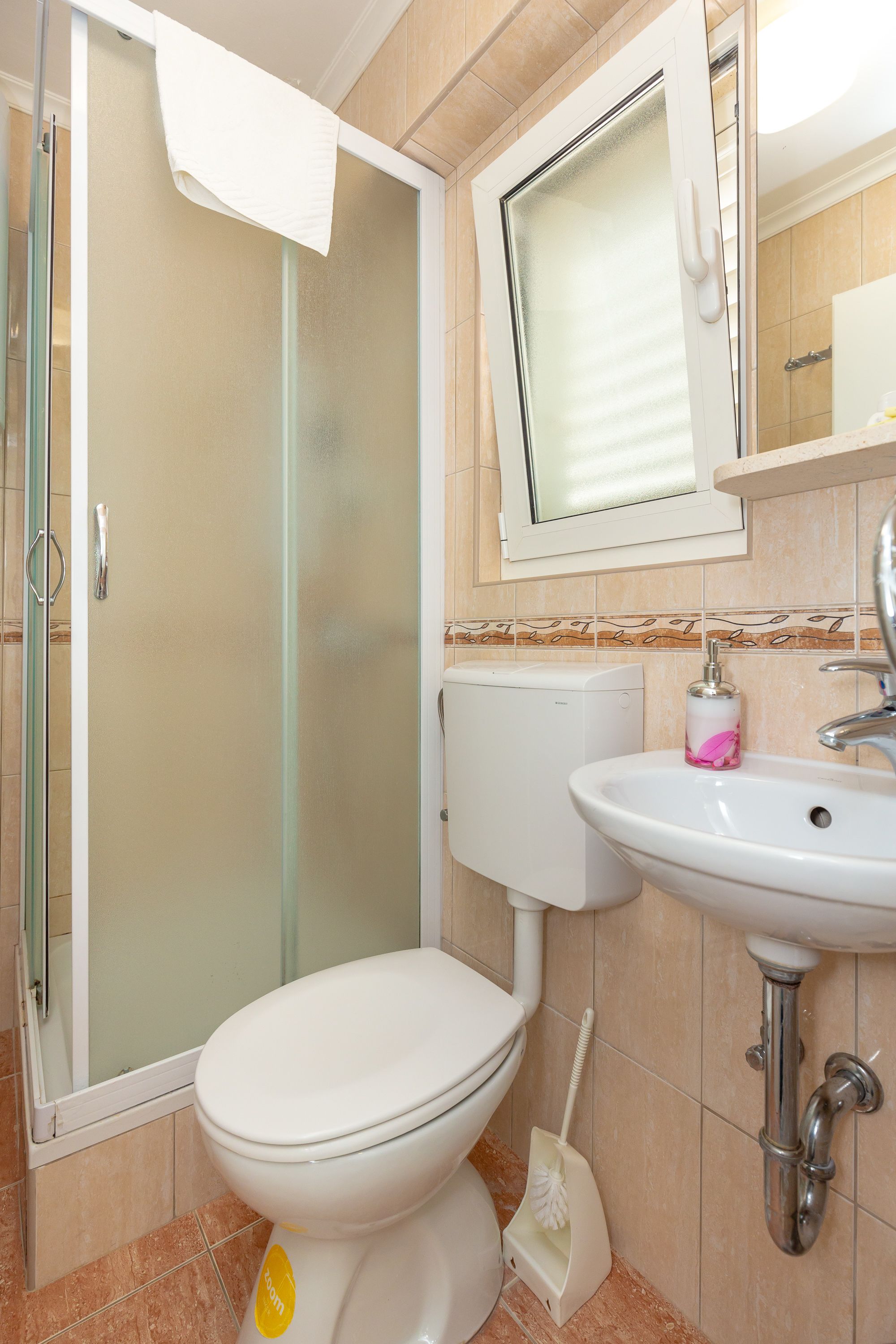 Ein Badezimmer mit Toilette, Waschbecken und Dusche.