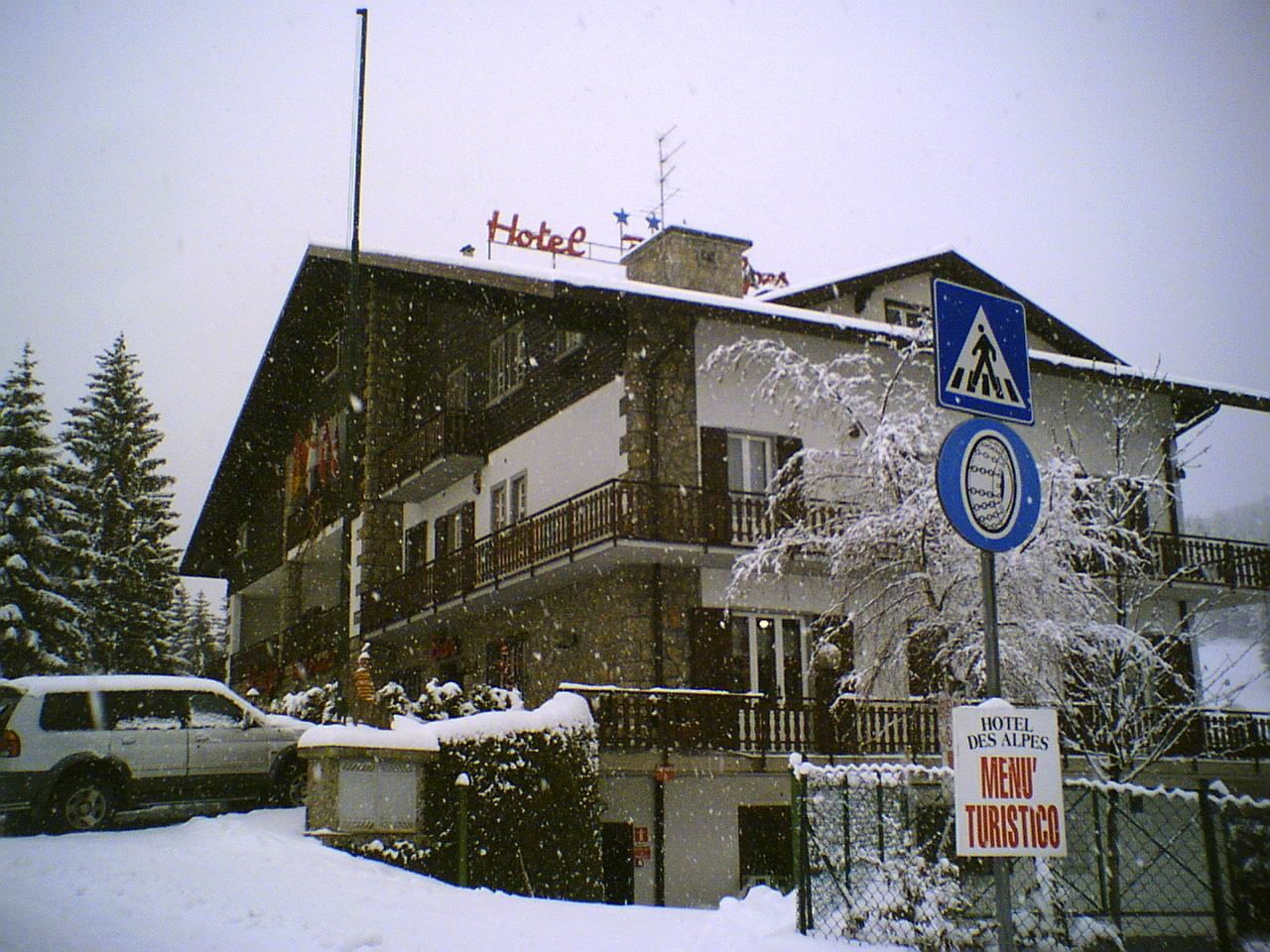 A hotel building with a sign indicating a tourist menu, surrounded by snow.