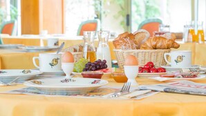 A breakfast setting with croissants, eggs, grapes, and tomatoes on a table. - A la Vignette (Saint-Hippolyte)