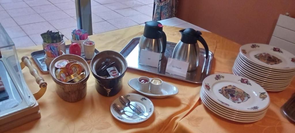 En frukostuppsättning med ett bricka, kaffekannor och staplade tallrikar.