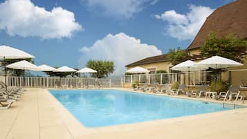 Una piscina al aire libre de temporada, sombrillas