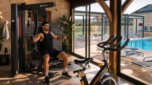 Un gimnasio con equipo de ejercicio, una piscina y vistas al exterior.