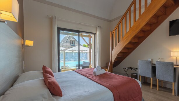 Un dormitorio con cama, escritorio, silla y vistas a un edificio.