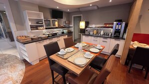 Una cocina moderna con comedor, equipada con refrigerador, microondas y cafetera.