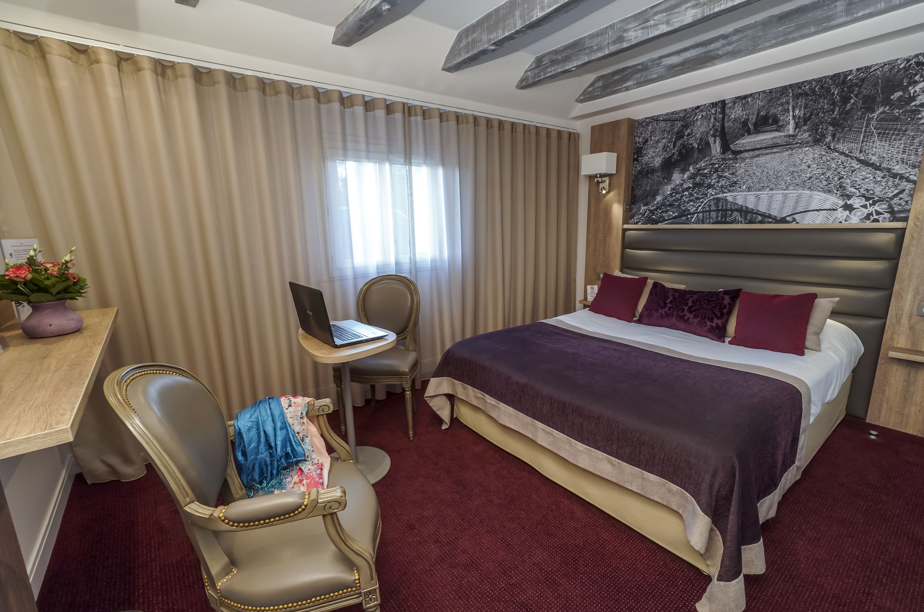 Une chambre d’hôtel équipée d’un lit, d’un bureau, d’une chaise et d’un ordinateur portable.