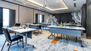 A modern conference room with multiple tables, laptops, and water bottles. - Mercure Samui Chaweng Tana Hotel (Koh Samui)