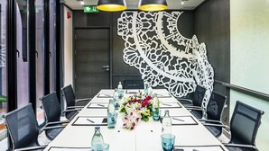 A conference room with a long table, chairs, and overhead lighting. - Mercure Samui Chaweng Tana Hotel (Koh Samui)