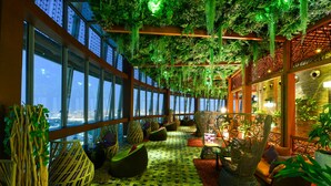 Een modern interieur met grote ramen, hangplanten en bijzondere zithoekjes.
