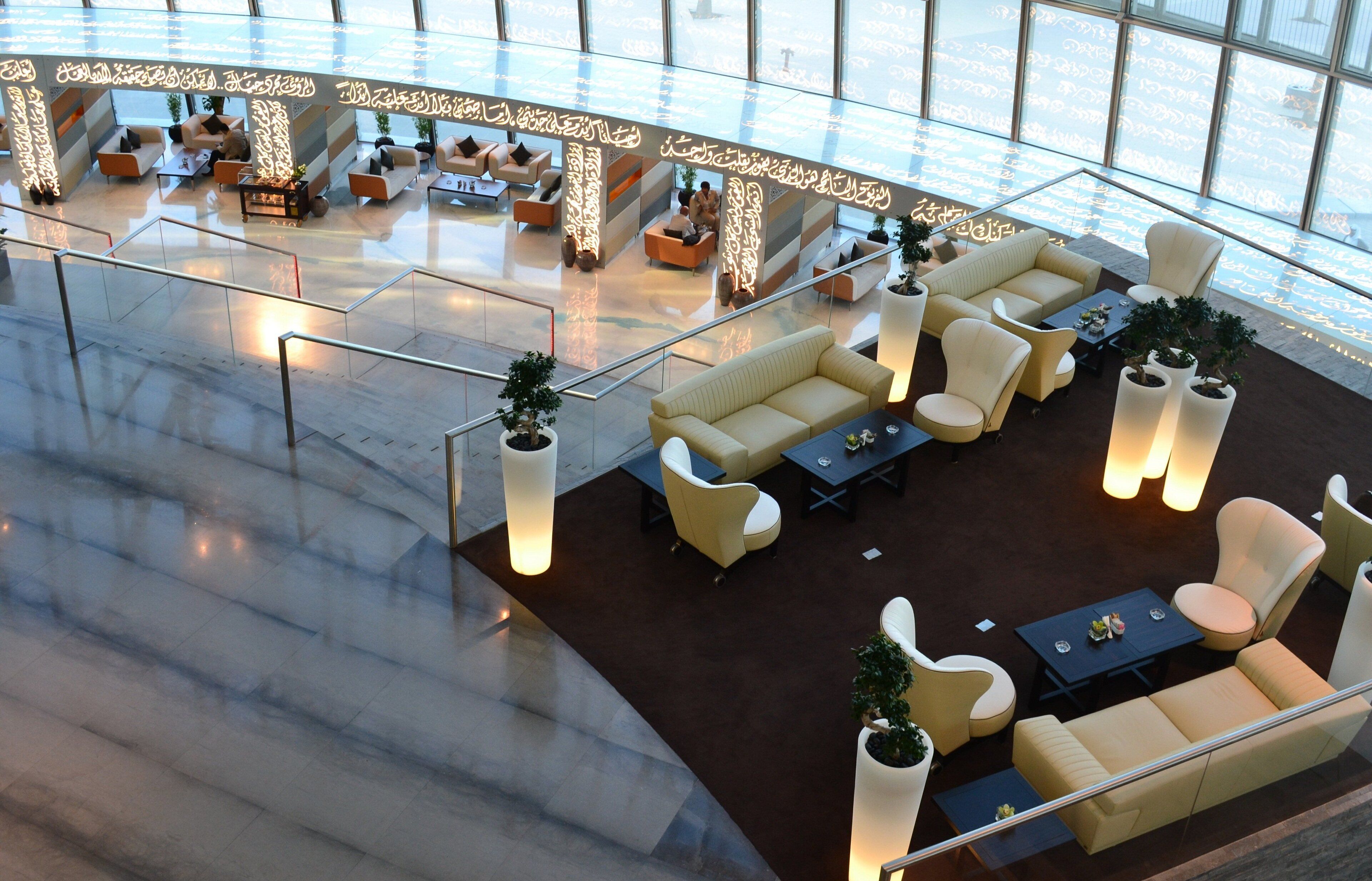 A spacious lobby with a high ceiling, modern seating arrangements, and large windows allowing natural light.