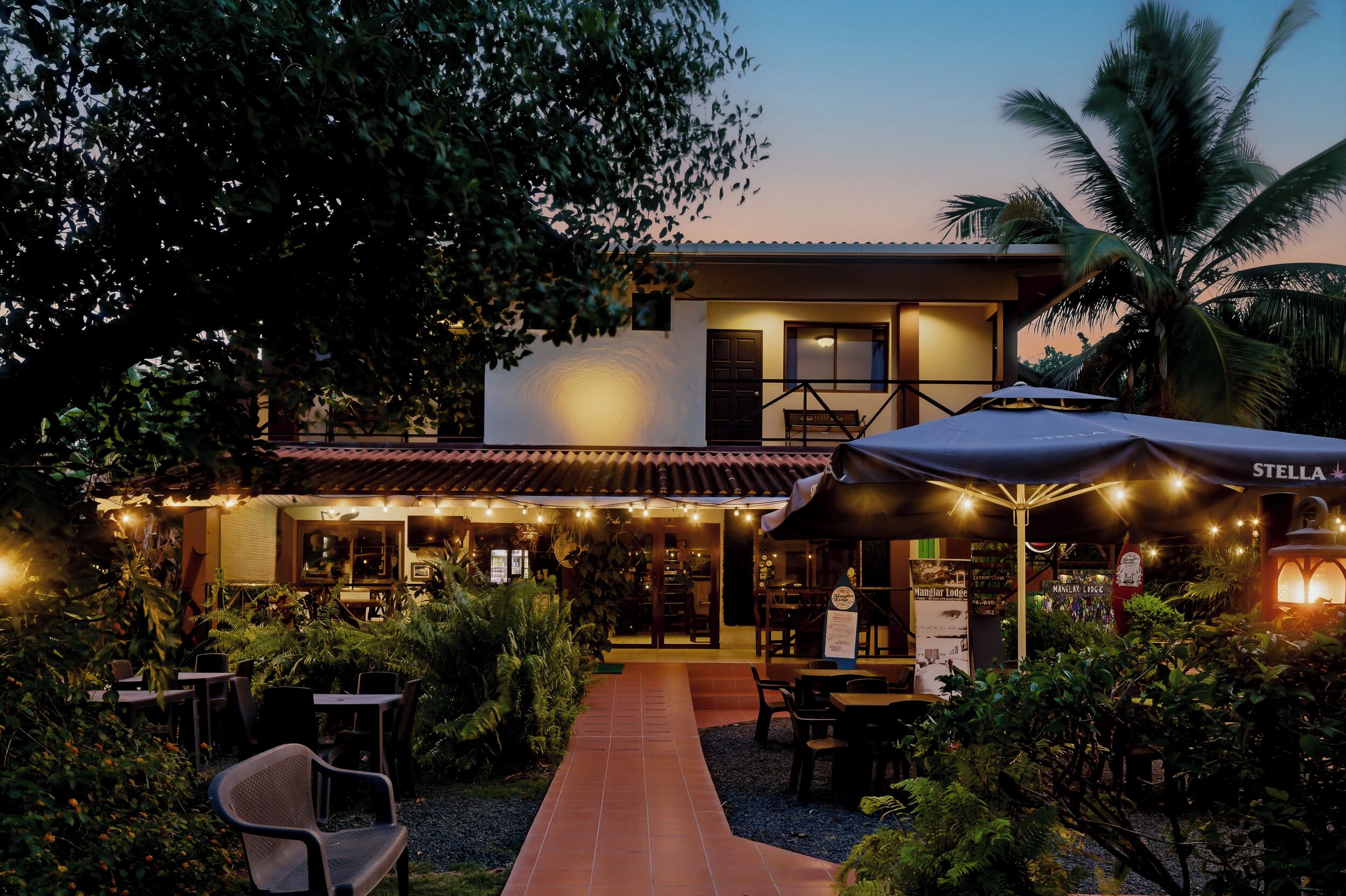 A restaurant with outdoor seating, a covered patio, and a sign reading 'STELLA.'