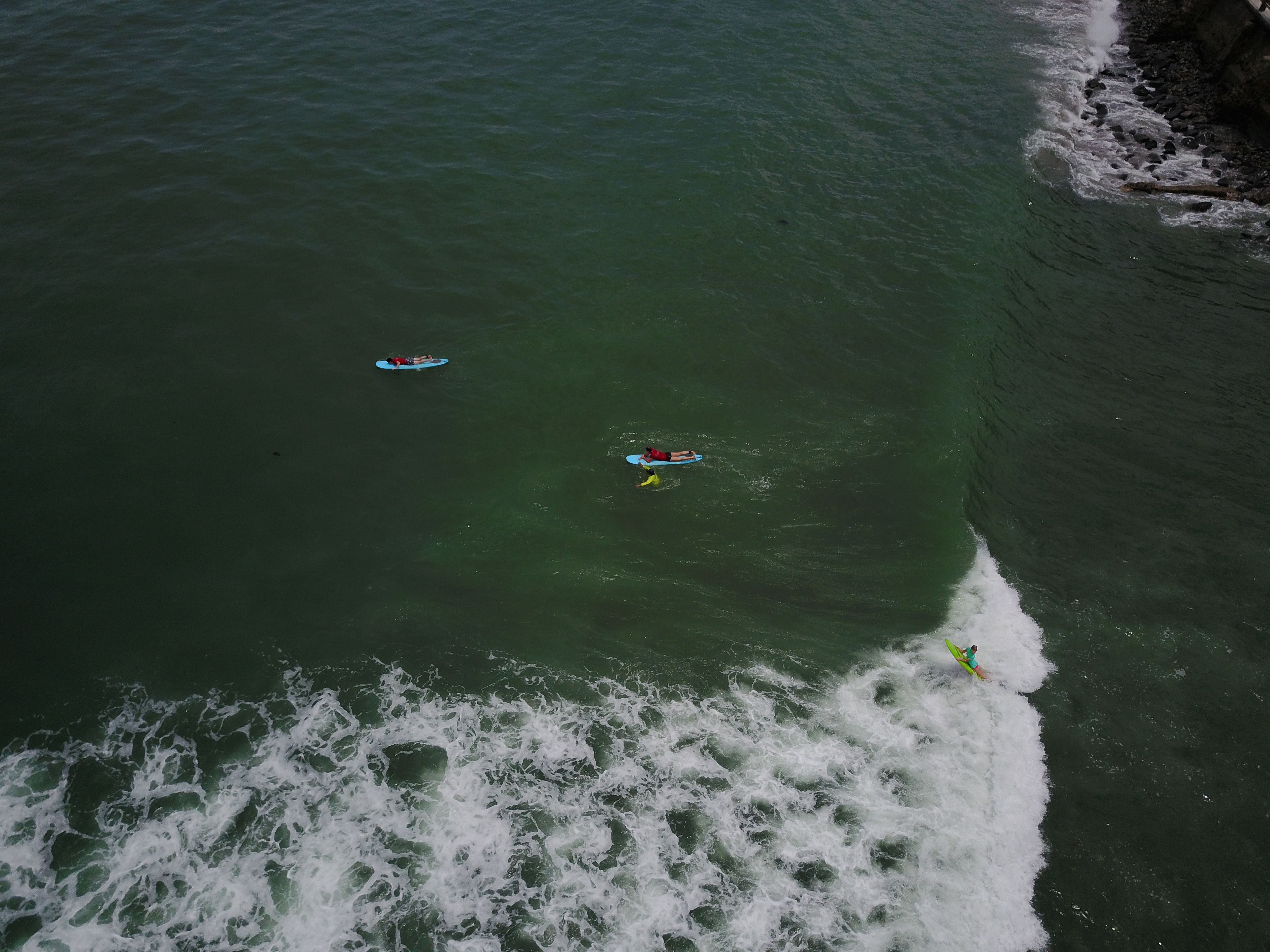 An aerial view of a coastal area with waves crashing onto the shore.