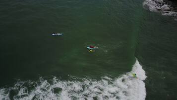 An aerial view of a coastal area with waves crashing onto the shore.