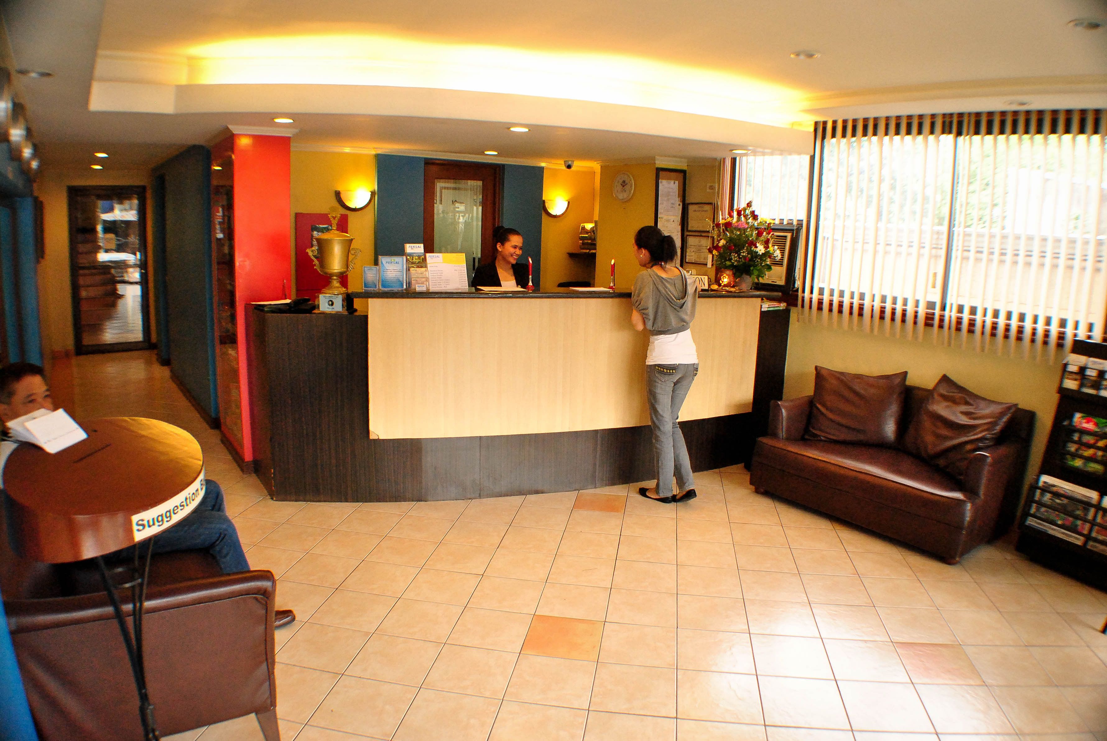 A reception area with a counter, a sofa, and a chair.