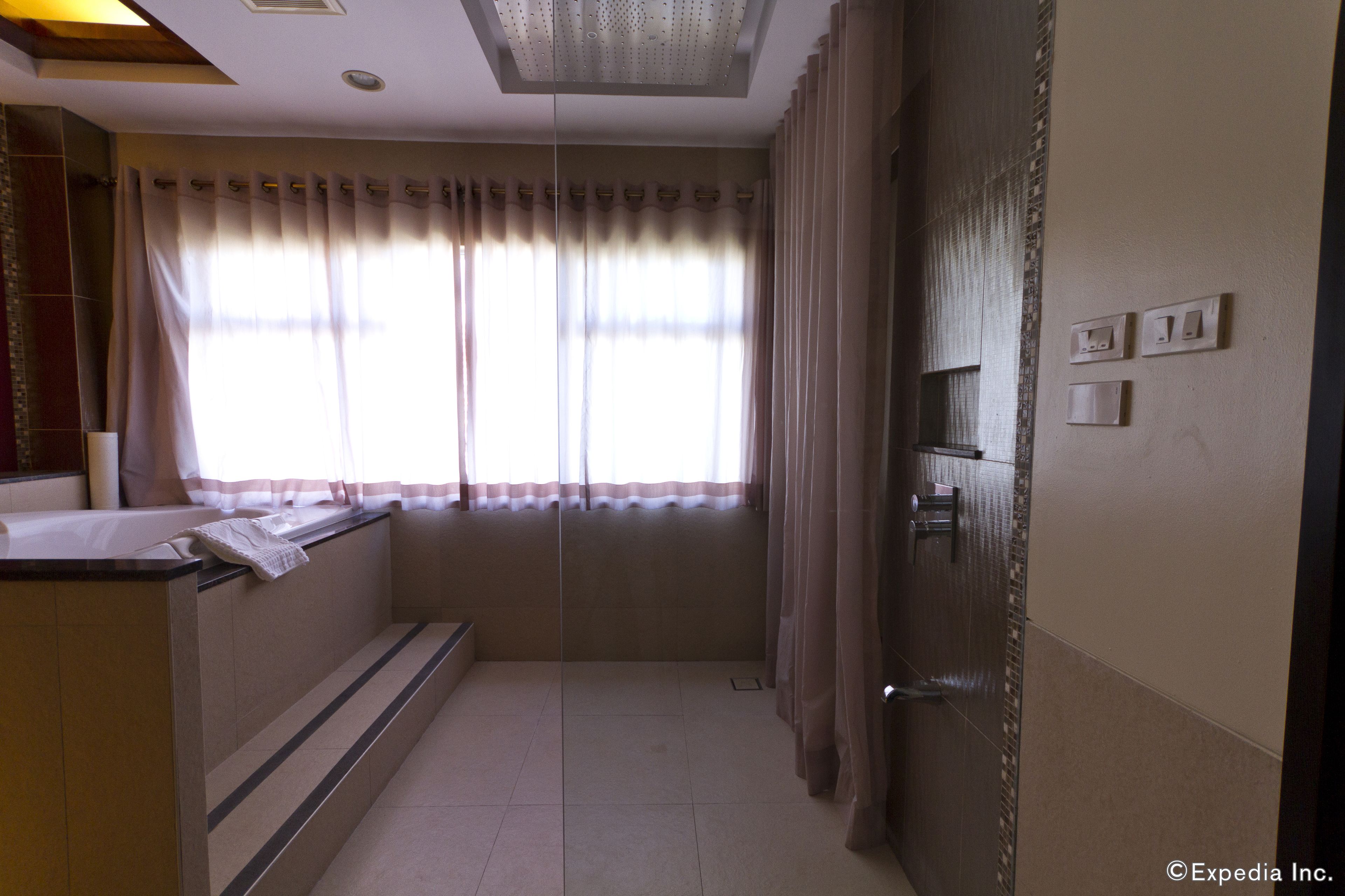 Un baño de hotel con bañera, ducha, lavabo e inodoro.